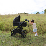 Kid holding and pushing Olive pram from Edwards & Co