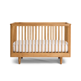 Wooden George Cot with a white mattress on a white background