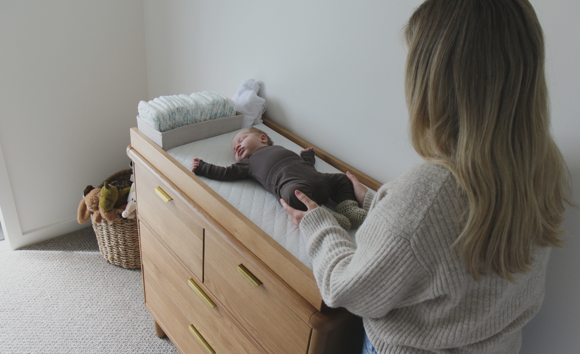 Mother with changing the baby on a George Dresser
