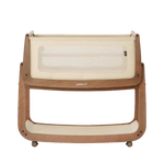 SnüzPod5 baby bassinet with a light natural wood frame, cream mesh safety netting, and cream fabric lining, shown on a plain white background.