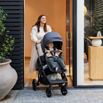 Mother smiling with baby inside Olive Double pram from Edwards & Co