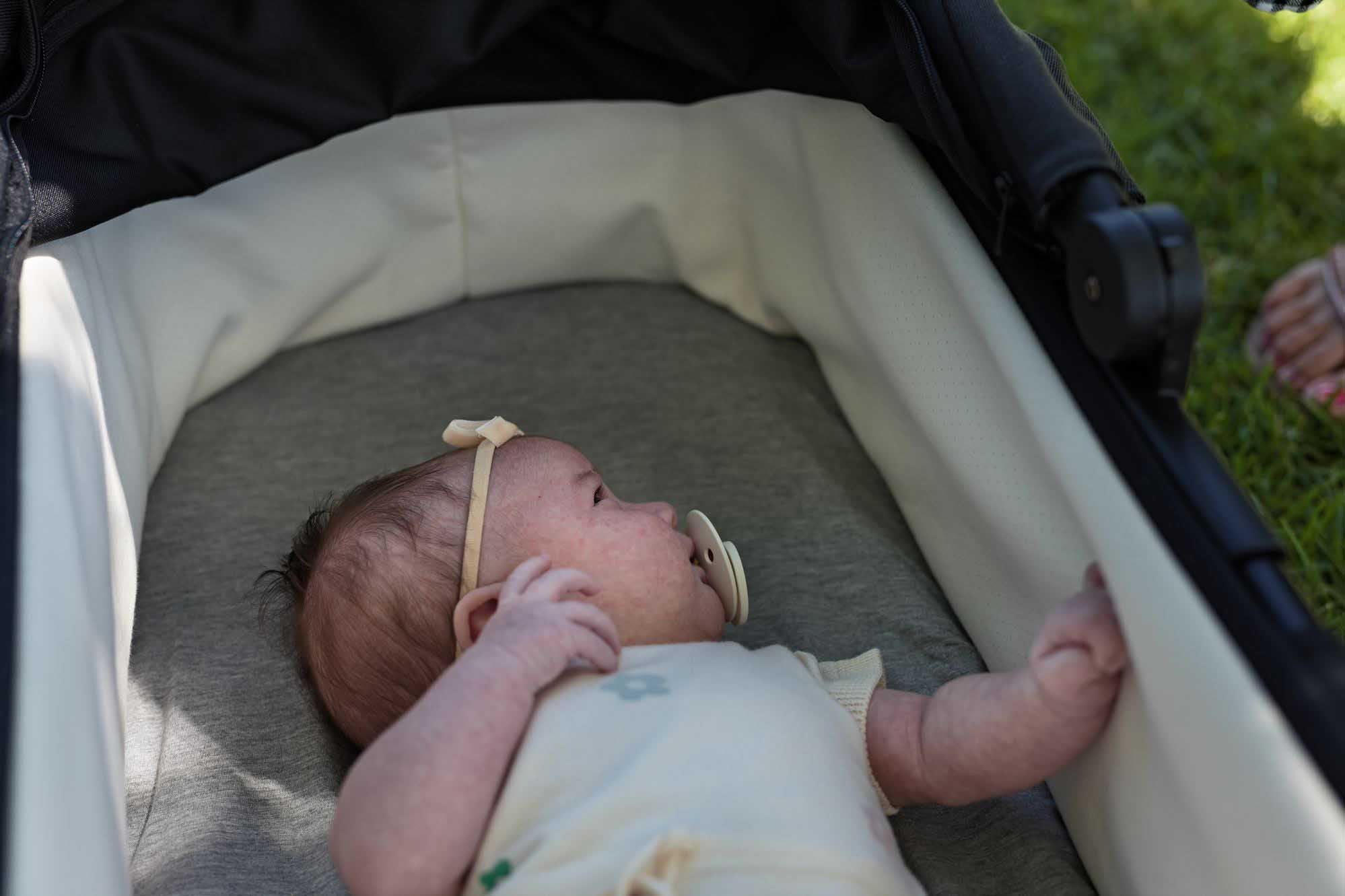 Baby in a carry cot with Bamboo Fitted Sheets
